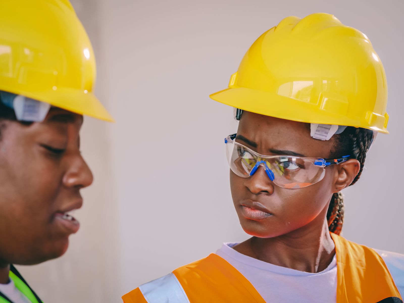 Black safety professionals in protective equipment having a workplace discussion