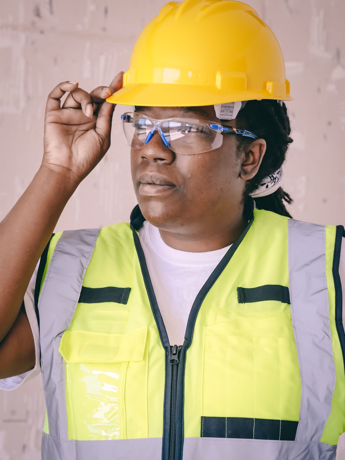 Black female safety professional wearing a hard hat, glasses and high-visibility vest